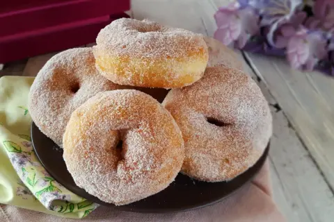 Graffe napoletane senza patate, soffici e dorate, ricoperte di zucchero. Un dolce che profuma di tradizione.