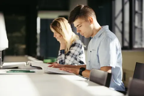 Estudiantes concentrados estudiando para entender como funcionan las oposiciones de maestro.