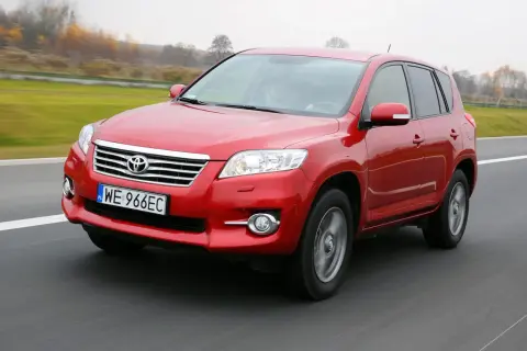Czerwony SUV do 30 tys. na drodze, z widocznym numerem rejestracyjnym WE 966EC.