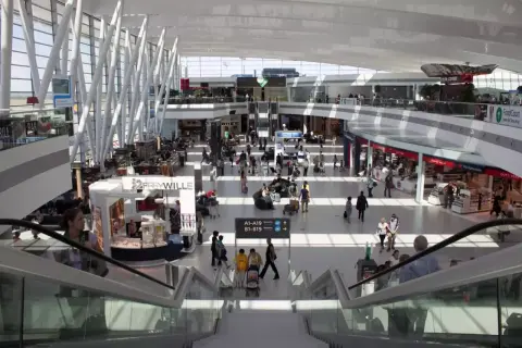 Tętniący życiem terminal lotnisko w Budapeszcie, z pasażerami spieszącymi do bram, sklepami i kawiarniami.
