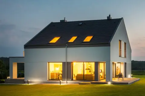Nowoczesny dom z jasnym, gładkim tynkiem zewnętrznym, który podkreśla jego architekturę. Różne rodzaje tynków zewnętrznych mogą nadać budynkowi unikalny charakter.