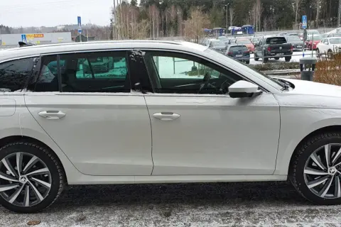 Vit Skoda Octavia laddhybrid parkerad i snö. Bilen har mörka fönster och snygga fälgar.