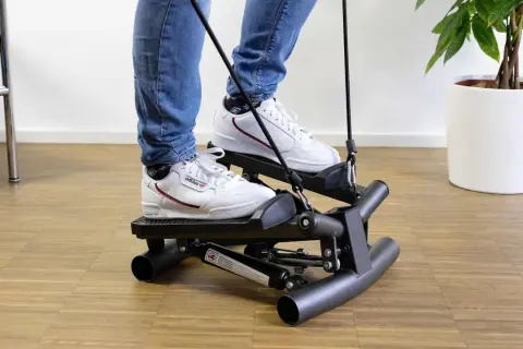 Person trainiert auf dem besten Stepper, um fit zu bleiben.