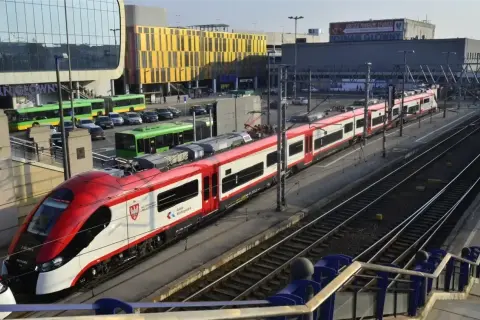 Koleje Wielkopolskie: rozkład jazdy Konin - Poznań. Nowoczesny pociąg na dworcu Poznań Główny, obok zielonych autobusów i samochodów.