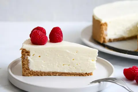 Ein cremiges Stück Cheesecake mit Himbeeren, perfekt für ein cheesecake rezept einfach.