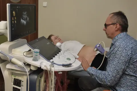 Lekarz wykonuje usg 3 trymestru. Na ekranie widać obraz płodu.