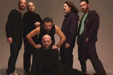 I Negramaro, in posa per "Quel posto che non c'è", sei uomini con sguardi intensi e abiti scuri.
