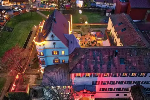 Luftaufnahme der Treuchtlinger Schlossweihnacht mit beleuchteten Buden und einem Weihnachtsbaum.