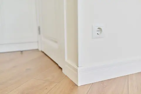 Los rodapiés blancos, igual que las puertas, crean un contraste elegante con el suelo de madera clara.