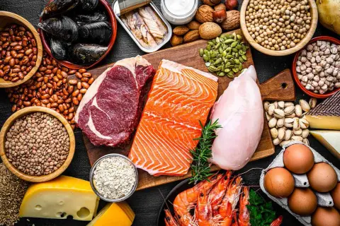 En variation av proteinrika livsmedel som biff, lax, kyckling, räkor, ägg, nötter, frön, bönor och ost. Bra för att planera hur mycket protein per dag.