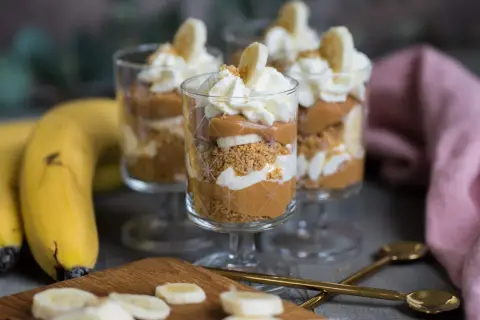 Tre glas med banoffee paj i lager av kexsmulor, kolasås, banan och grädde. Garnerad med bananskivor och strössel.