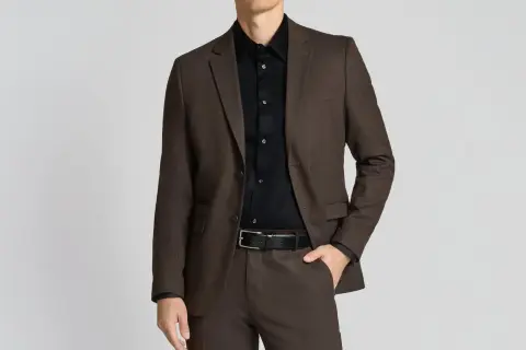 Mann im braunen Anzug mit schwarzem Hemd. So lässt sich ein schwarzes Hemd kombinieren für einen eleganten Look.