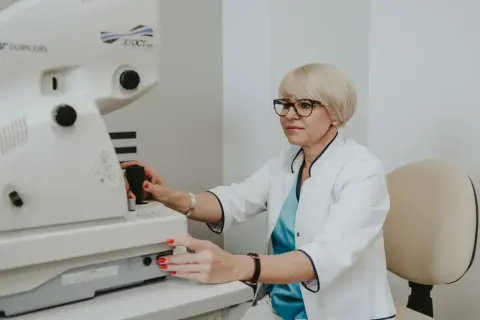 Okulistka wykonuje badanie dna oka za pomocą nowoczesnego urządzenia Topcon 3D OCT.