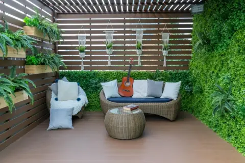 Un rincón acogedor para cerrar el patio exterior, con sofá, sillón, mesa y guitarra.