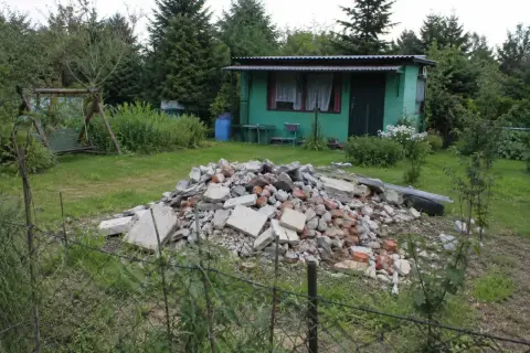 Ziemia na sprzedaż! Gruz i śmieci na działce z domkiem i huśtawką.