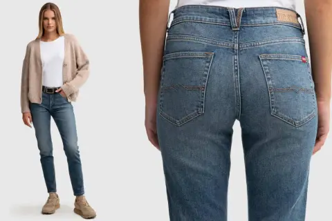 Modelka w beżowym kardiganie i białej bluzce prezentuje jeansy: spodnie szerokie w udach, wąskie w łydkach.