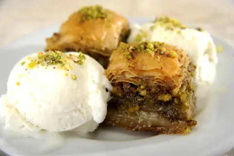 Délicieux baklava recette servi avec de la glace à la vanille, saupoudré de pistaches concassées.