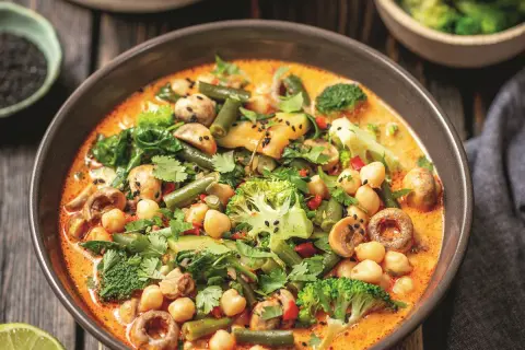Aksamitne curry z ciecierzycy z brokułami, fasolką szparagową i grzybami, posypane czarnym sezamem.