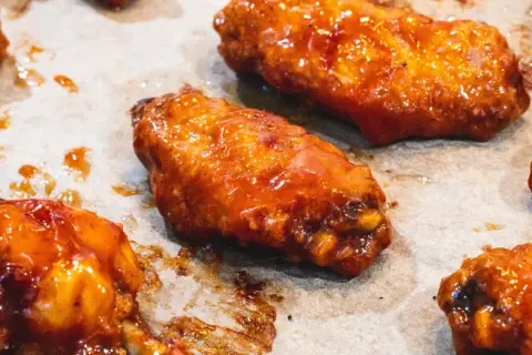 Saftige Hähnchenflügel in einer glänzenden, würzigen Marinade, bereit zum Genuss.