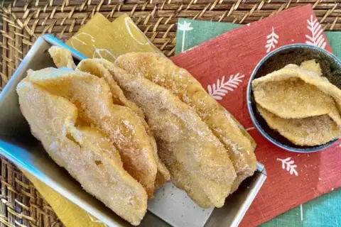 Cresciole marchigiane dorate e zuccherate, un dolce fritto che profuma di tradizione.