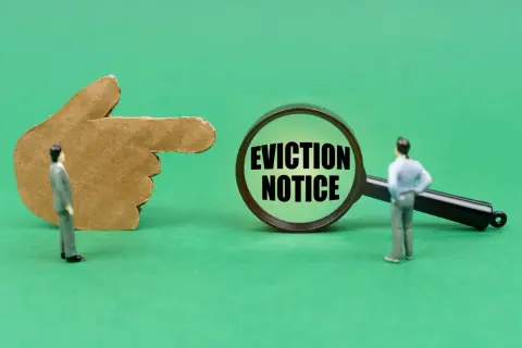 Dito un dito di cartone indica una lente d'ingrandimento con la scritta "EVICTION NOTICE". Un omino guarda la lente, suggerendo un imminente sfratto per finita locazione e canoni non pagati.