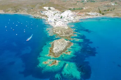 Vista aérea de la isleta de Cabo de Gata, con casas blancas, barcos y aguas cristalinas.