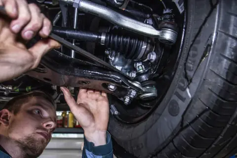 Mechanik pracuje pod samochodem. Prawdziwa historia klienta, który stracił gwarancję przez wymianę klocków poza ASO.