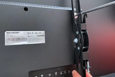 Montaż telewizora na ścianie bez uchwytu? To możliwe! Wkręcanie elementów mocujących do tyłu telewizora Sharp.
