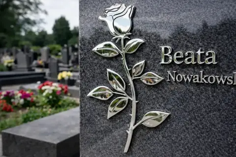 Na nagrobku Beaty Nowakowskiej widnieje metalowa róża, symbol miłości i pamięci. W tle cmentarz.