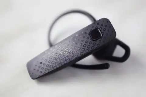 Czarna słuchawka Bluetooth z ozdobnym wzorem kółek. Dowiedz się, jak sparować słuchawki z telefonem, by cieszyć się muzyką bez kabli.