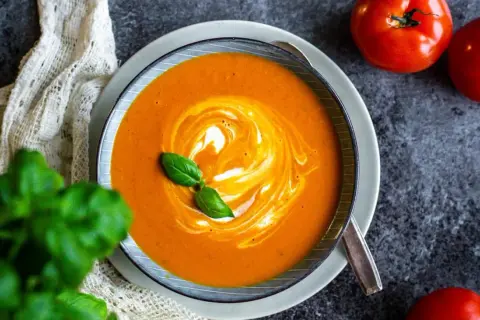 Krämig tomatsoppa med virvlar av grädde och färsk basilika. Ett perfekt tomatsoppa recept för en mysig kväll.