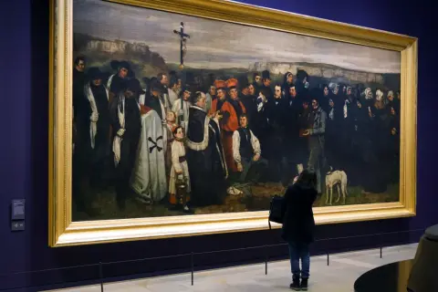 Obraz przedstawia pogrzeb w Ornans, z żałobnikami i duchownymi zgromadzonymi wokół krzyża.
