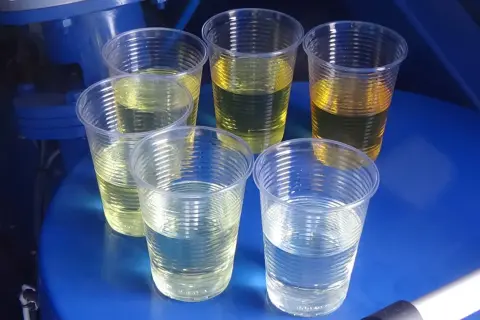Próbki płynów w kubeczkach, niektóre żółte, inne klarowne. Może to być test porównawczy przed zastosowaniem ceramizera, by uniknąć jego wad.