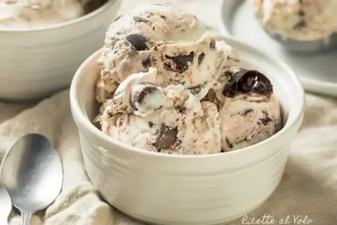 Coppette di gelato fatto in casa senza gelatiera, con pezzi di cioccolato e ciliegie.
