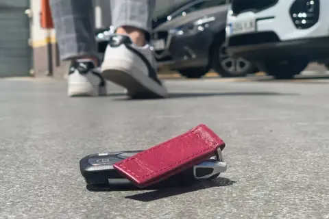 ¡Ay no! He perdido las llaves del coche. Están tiradas en el suelo, cerca de unos zapatos y coches aparcados.