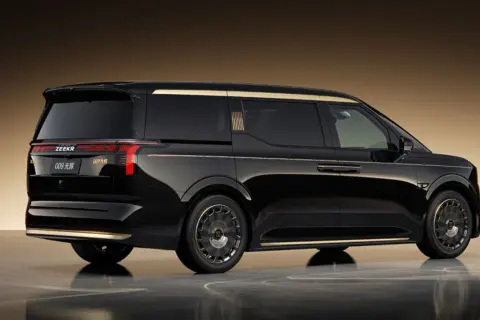 Svart Zeekr 009 med gulddetaljer, sedd från sidan och bakifrån. Lyxig MPV med elegant design.