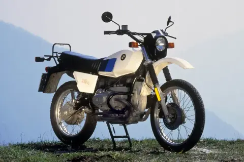 Una BMW R80GS, una icónica moto de los 80, lista para la aventura en un paisaje montañoso.