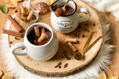 Cioccolata calda cremosa in tazza, con biscotti arrotolati e tavoletta di cioccolato. Un abbraccio goloso per le giornate autunnali.