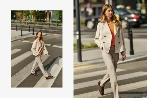 Elegancka beżowa marynarka damska w połączeniu z jasnymi spodniami i pomarańczową bluzką tworzy stylowy miejski look.