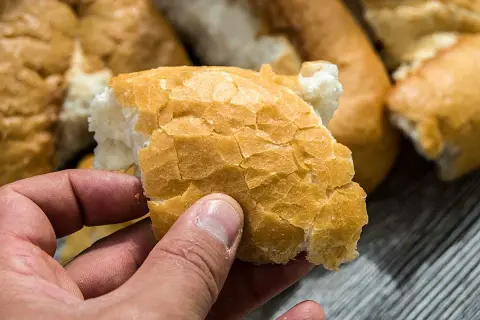 Czerstwy chleb w dłoni. Zastanawiasz się, co zrobić z czerstwego chleba? Idealny na grzanki lub bułkę tartą.