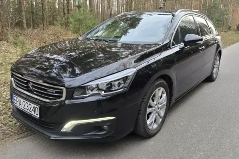 Czarny Peugeot 508 kombi z silnikiem 2.0 HDI 150KM na leśnej drodze.