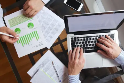 Analiza wyników finansowych, gdzie widać wykresy i dane. Dyskusja o tym, jak podatek progresywny wpływa na dochody.