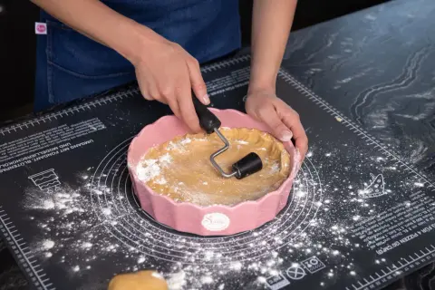 Sallys Kekse: Hände formen Teig in einer rosa Form auf einer Backmatte.
