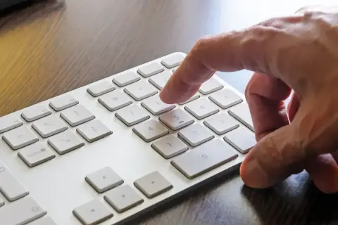 Dłoń naciska klawisz 8 na klawiaturze numerycznej, aktywując funkcję num lock.