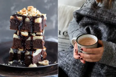 Gestapelte Cheesecake Brownies mit Schokoladenglasur und Nüssen, daneben eine Tasse Kakao.