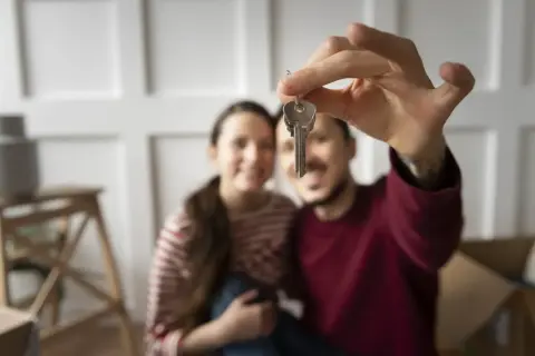Coppia felice con le chiavi in mano, pronti per i tre passaggi per non farsi fregare quando vendi casa.