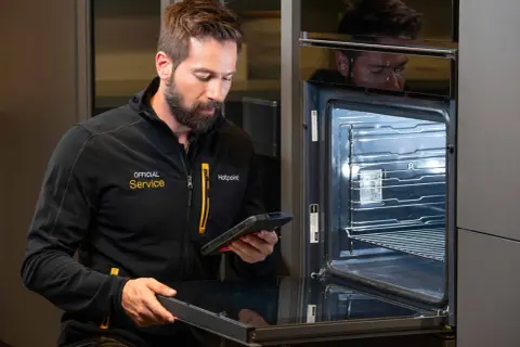 Serwisant z tabletem sprawdza instrukcję mastercook plus piekarnik.