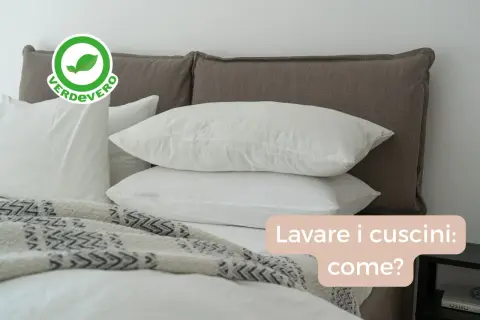 Bianchi cuscini su un letto, con un logo "Verdevero". Impara come lavare i cuscini in lavatrice per mantenerli freschi e puliti.