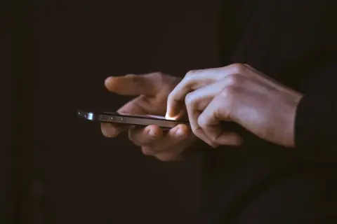 Mains utilisant un smartphone, frustrées par une application qui se ferme toute seule sur Android.