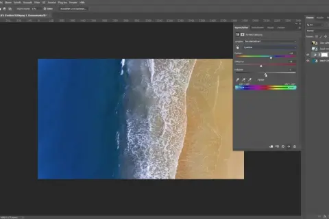 Un homme ajuste les curseurs de teinte, saturation et luminosité dans Photoshop pour changer la couleur d'une photo de plage.